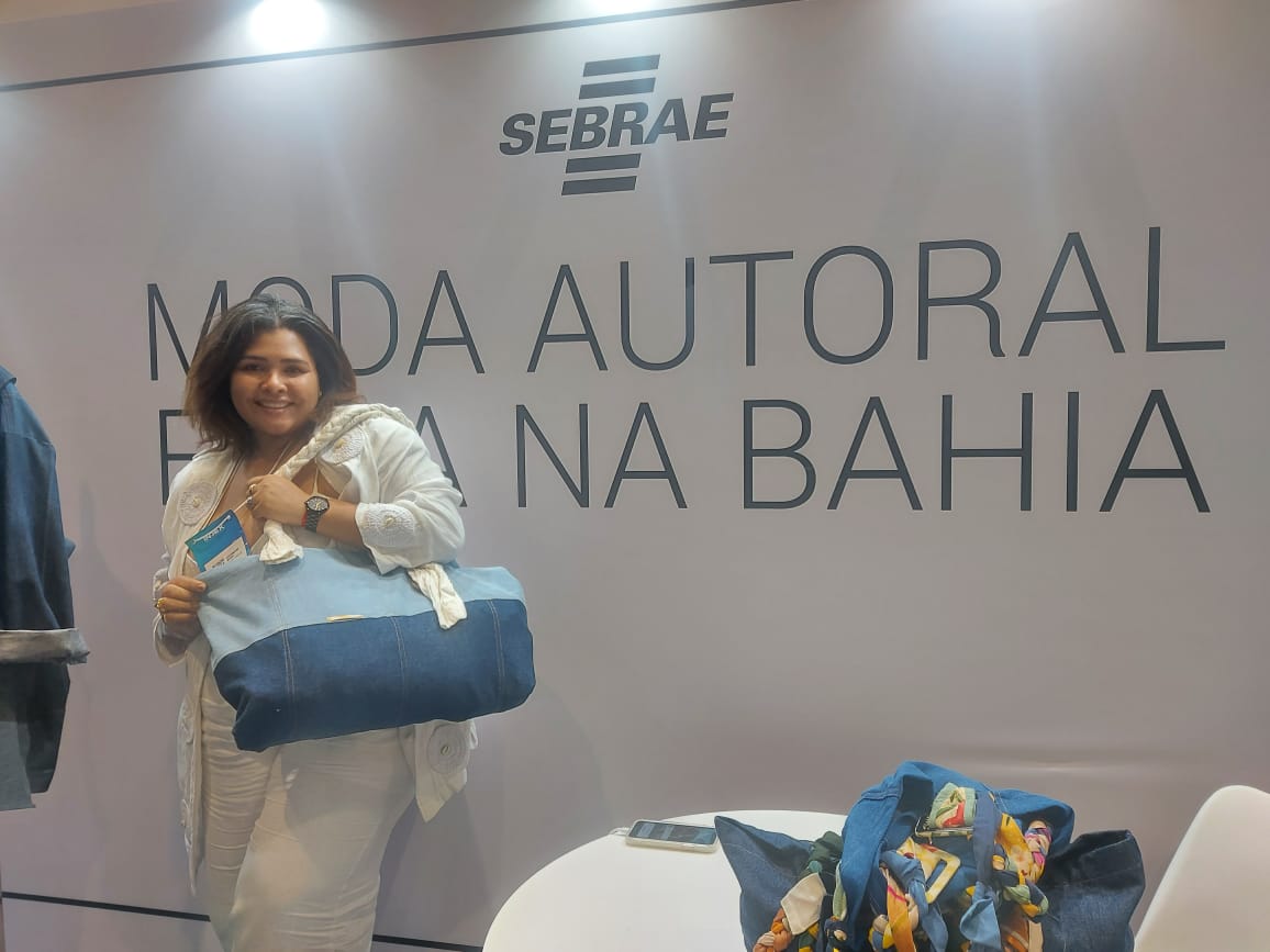 Lorrani segurando bolsa autoral feita de pedaços de jeans