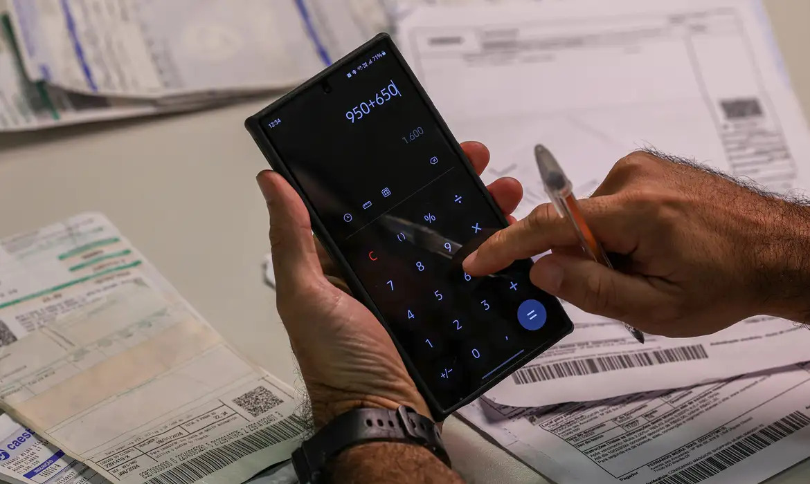 Mão segurando calculadora 