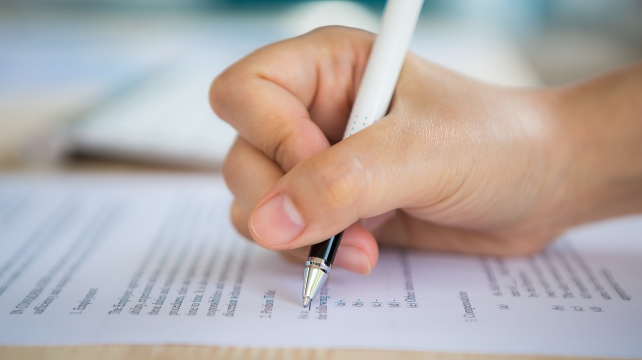 mulher segurando caneta enquanto faz prova