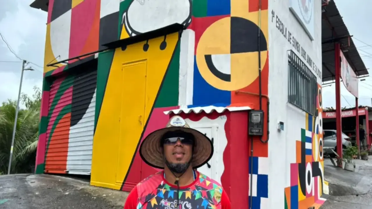 imagem de homem na frente da primeira escola de samba junino.