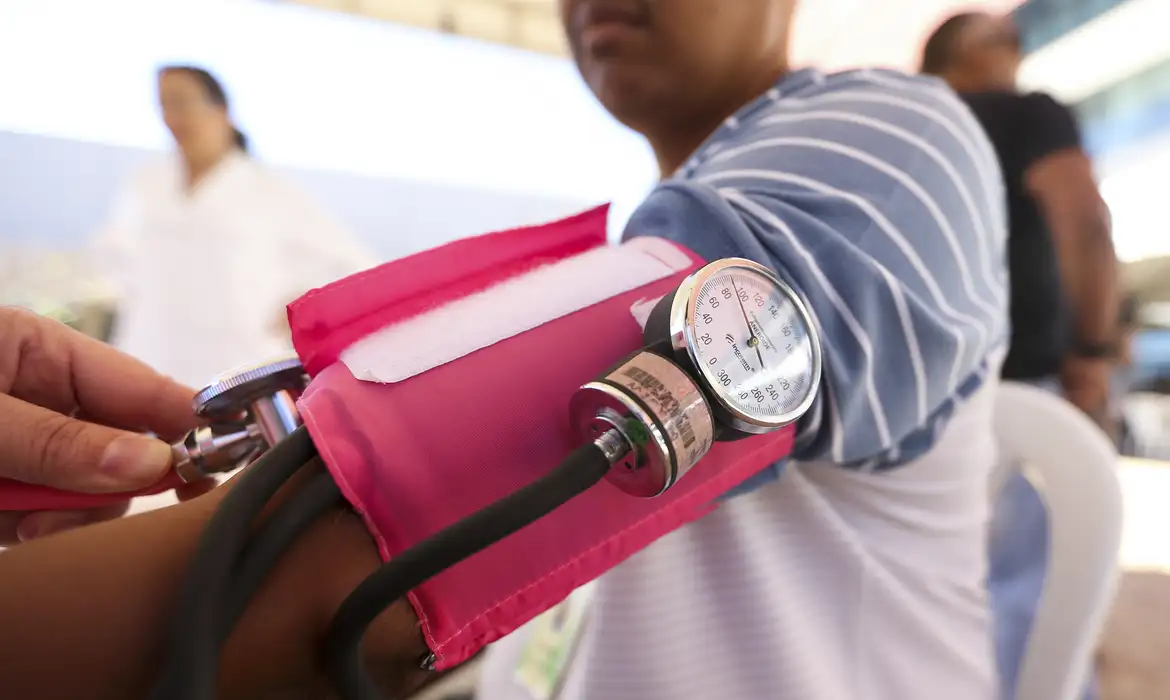 pessoa com aparelho de medir pressão arterial