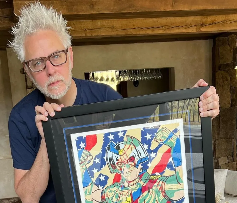 James Gunn em sua casa segurando um quadro de um flme
